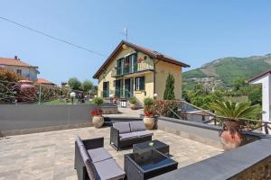 a house with a patio with chairs and a table at Villa Degli Dei in Agerola