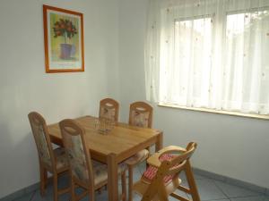 a dining room table with chairs and a wooden table at Ferienwohnung Mengelberg in Markkleeberg