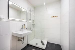 a white bathroom with a sink and a shower at Fewo Sonnenaufgang, Ausblick in Augsburg +12 photos