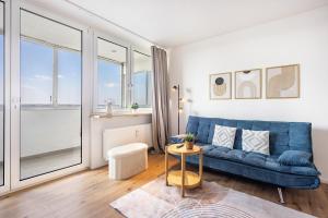 a living room with a blue couch and a table at Fewo Sonnenaufgang, Ausblick in Augsburg