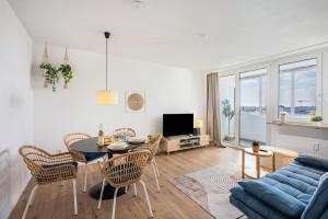 a living room with a table and a blue couch at Fewo Sonnenaufgang, Ausblick in Augsburg