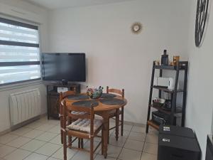 a dining room with a table and a television at Meublé 3 étoiles en centre-ville in Niederbronn-les-Bains