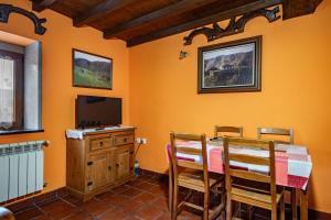 a dining room with a table and a television at Casa Rural Ricao in Cangas de Onís
