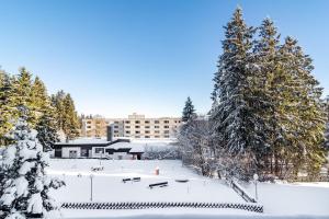 a building covered in snow with trees in the foreground at Räuberhöhle in Goslar