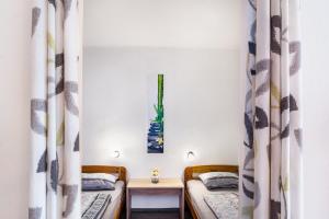 two beds in a small room with curtains at Räuberhöhle in Goslar