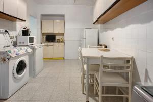 a kitchen with a washing machine and a table with chairs at Casa Paola in Levanto