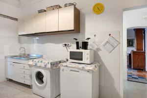 a kitchen with a washing machine and a microwave at Casa Paola in Levanto +6 photos