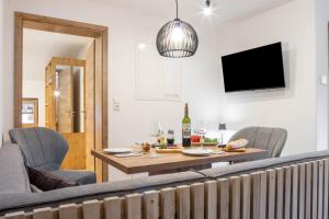 a living room with a table and chairs and a tv at Allpano Pension und Ferienwohnungen in Dietmannsried