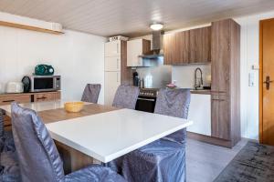 a kitchen and dining room with a white table and chairs at Villa Sonnenwinkel in Todtmoos