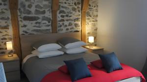 a bedroom with a bed with four pillows at La Trouverie in Laqueuille