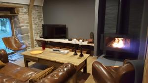 a living room with a couch and a fireplace at La Trouverie in Laqueuille