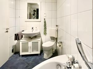 a white bathroom with a toilet and a sink at Ferienwohnung Ate´s kleine Welt in Brilon