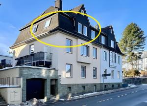 a large white house with a yellow circle on it at Ferienwohnung Ate´s kleine Welt in Brilon