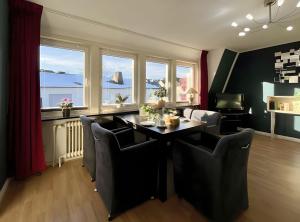 a dining room with a table and chairs and windows at Ferienwohnung Ate´s kleine Welt in Brilon