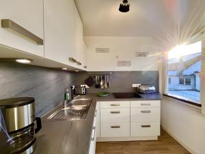 a kitchen with white cabinets and a sink at Ferienwohnung Ate´s kleine Welt in Brilon +16 photos