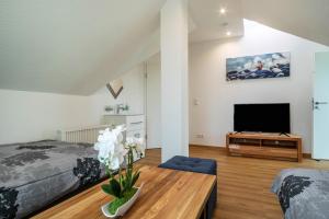 a living room with a bed and a tv at Ferienwohnung Alpenblick in Friedrichshafen