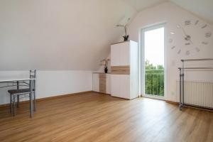 a white room with a clock on the wall and a table at Ferienwohnung Alpenblick in Friedrichshafen +12 photos