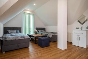 a bedroom with two beds and a table at Ferienwohnung Alpenblick in Friedrichshafen