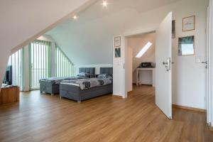 a large bedroom with a bed and a wooden floor at Ferienwohnung Alpenblick in Friedrichshafen