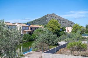 a river with houses and a mountain in the background at Que Bo in Alcudia