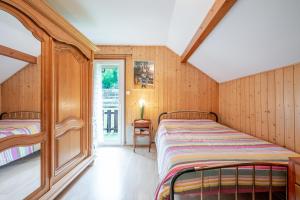 a bedroom with two beds in a room with wooden walls at Villa près du lac in Étercy +24 photos
