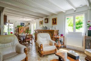 a living room with a couch and a table at Villa près du lac in Étercy