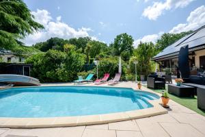 a swimming pool in a yard with chairs at Villa près du lac in Étercy