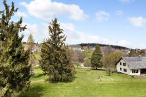 a field with trees and a house in the background at Isabell in Schönwald