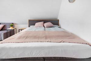 a bed with two pink pillows on top of it at Isabell in Schönwald +15 photos