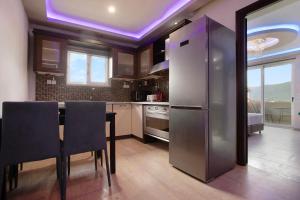 a kitchen with a refrigerator and a table with chairs at Villa Dionysia Apartment A2 in Alikanas