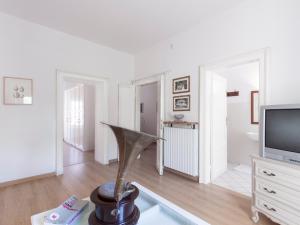 a living room with a television and a table at Delicious House Michelangelo in Cavaion Veronese