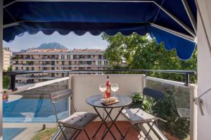 a table with two chairs and a bottle of wine on a balcony at Lake Como Design Home in Lecco