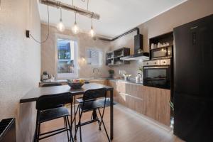 a kitchen with a black refrigerator and a table with chairs at Lake Como Design Home in Lecco