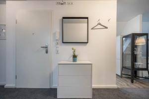 a white room with a mirror and a table at Appartment Malerviertel in Braunschweig +11 photos