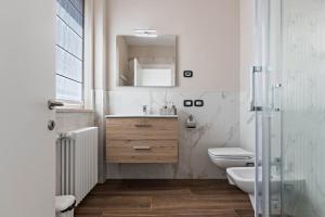 a bathroom with a sink and a toilet and a mirror at Villa Vacanze Renetta in Tuenno