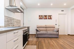 a kitchen with a couch and a chair in a room at Villa Vacanze Renetta in Tuenno