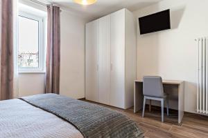 a bedroom with a bed and a desk and a television at Villa Vacanze Renetta in Tuenno