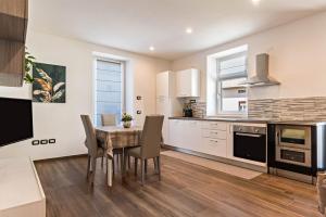 a kitchen with a table and chairs in a kitchen at Villa Vacanze Renetta in Tuenno +14 photos