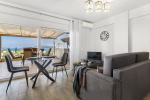a living room with a couch and a table and chairs at Evagelia Luxury Apartment 2 in Nikiana