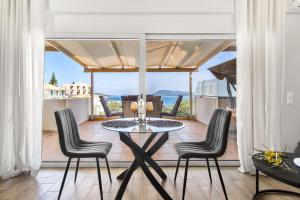 a dining room with a table and chairs on a balcony at Evagelia Luxury Apartment 2 in Nikiana