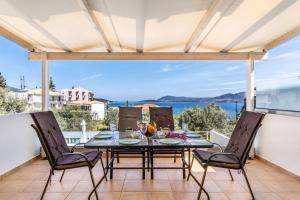 a dining table on a balcony with a view of the ocean at Evagelia Luxury Apartment 2 in Nikiana