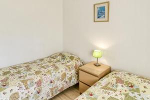 a bedroom with two beds and a lamp on a night stand at Platja Mar 3º in L'Escala