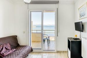 a living room with a couch and a view of the ocean at Platja Mar 3º in L'Escala
