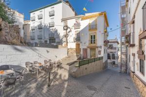 an alley with tables and chairs and buildings at Casa Ramirez in Güéjar-Sierra