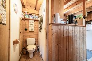 a bathroom with a toilet in a wooden cabin at Chalet 6p Classique - Le Marmotton in Verchaix