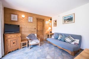 a living room with a couch and a tv at La mouliniere 2 in Valloire