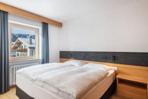 a bedroom with a large bed and a window at La Grambla App Mont Seuc 1 in Santa Cristina Gherdëina