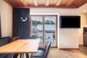 a dining room with a table and a tv at La Grambla App Mont Seuc 1 in Santa Cristina Gherdëina