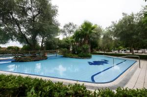 a large blue swimming pool with trees in the background at Casa Tina in Sorrento