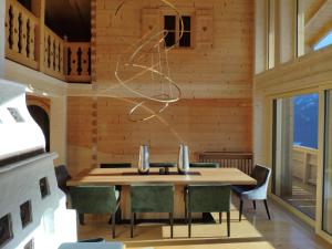 a dining room with a wooden table and chairs at Chalet Sonnberg Bramberg in Bramberg am Wildkogel